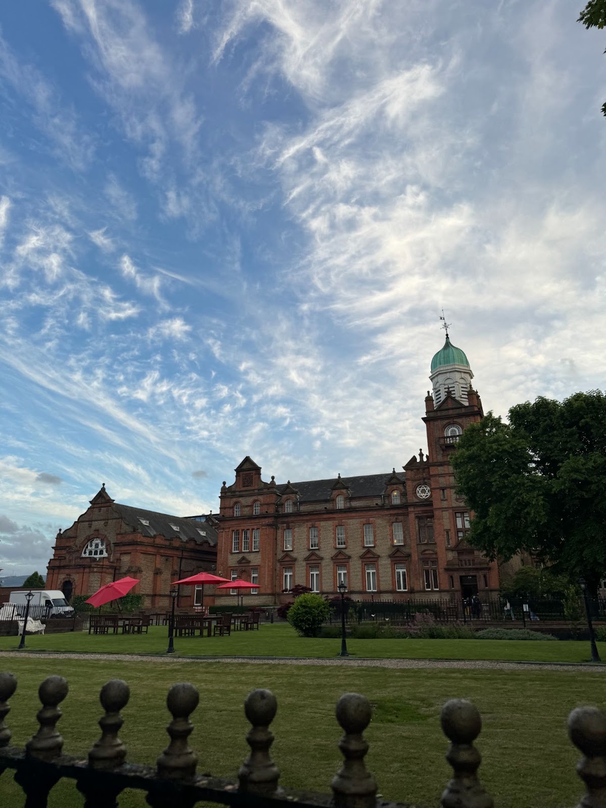A red-brick building with a copper dome under a cloudy sky in Dublin